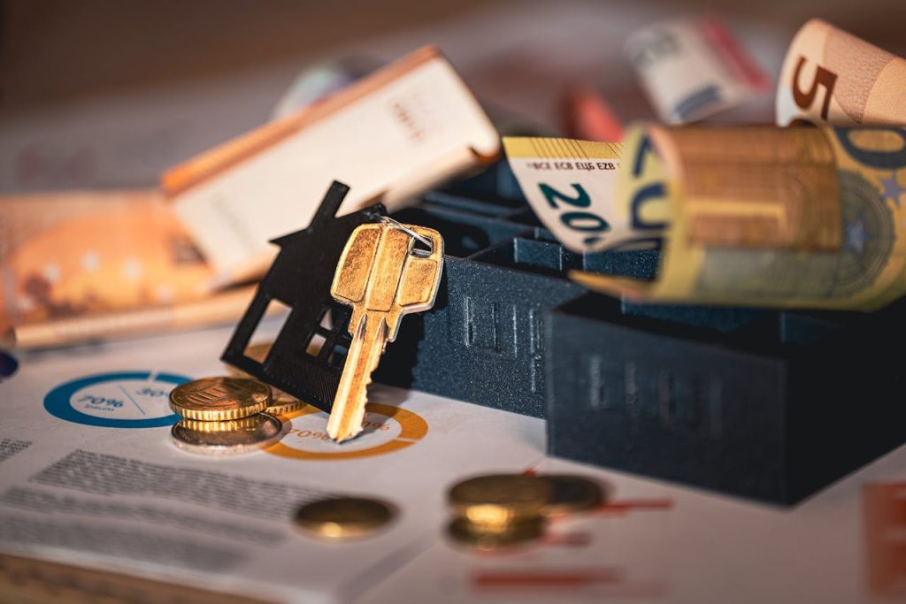 real-estate-investment-essentials-with-euro-currency-29799518 Close-up of house keys, euro bills, and charts symbolizing real estate investment and finance.
